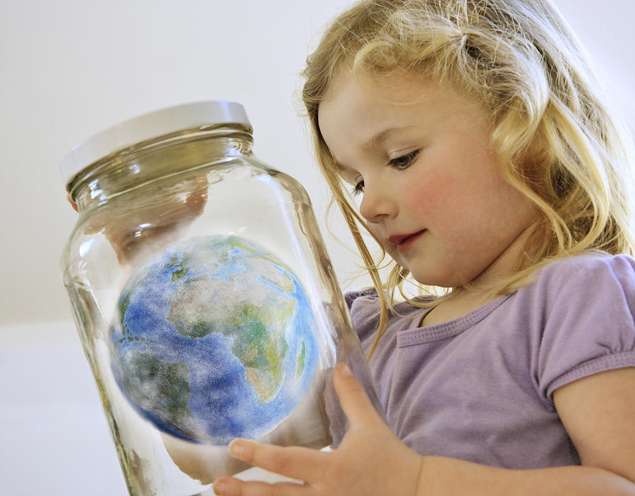 Young Girl Looking At The World In A Jar. Photograph by David Malan