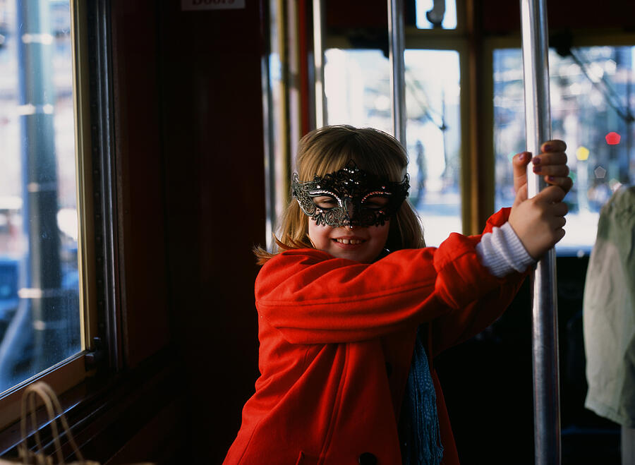 Young girl on New Orleans streetcar wearing Mardi Gras mask Photograph by Scott Zdon