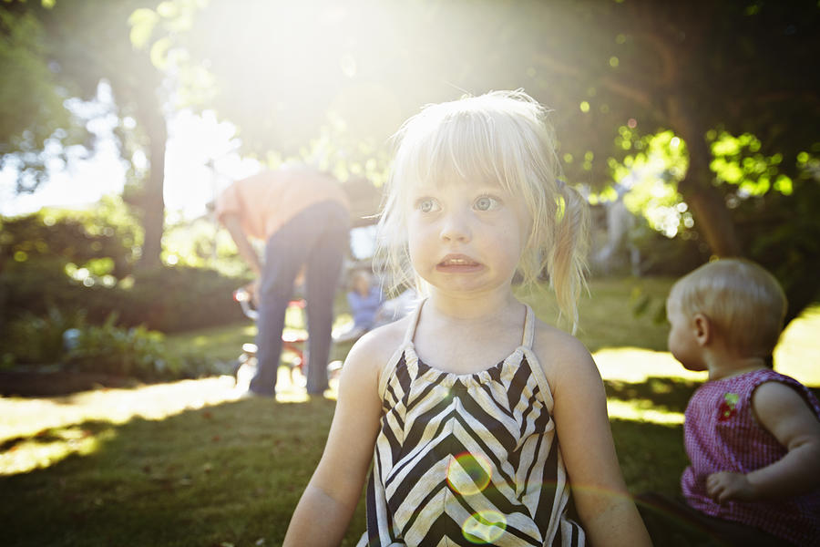 Young girl playing on grass in backyard Photograph by Thomas Barwick