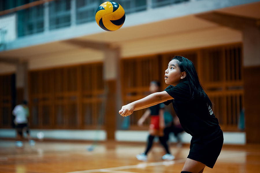 Young girl playing volleyball at a team practice in a school gym Photograph by Trevor Williams