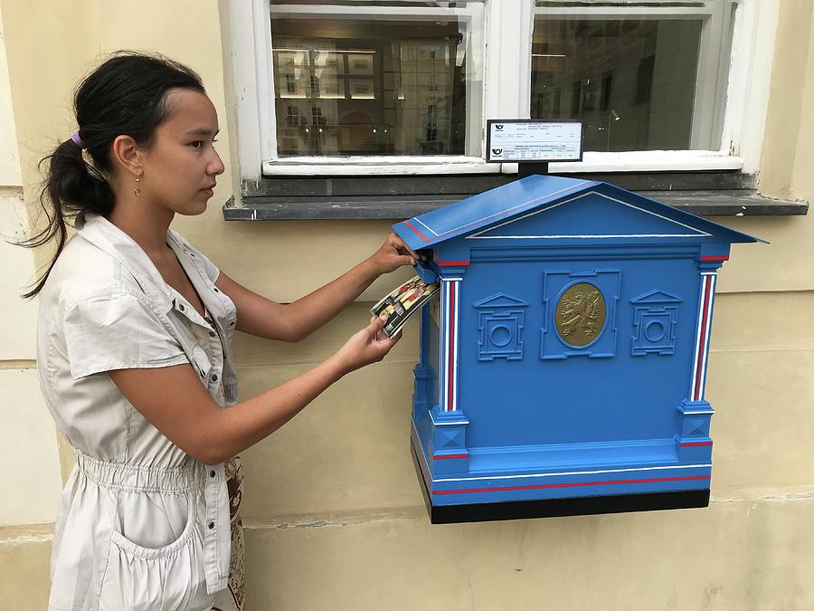 Young Girl Putting Postcards into a Mailbox Photograph by Jan Dolezal