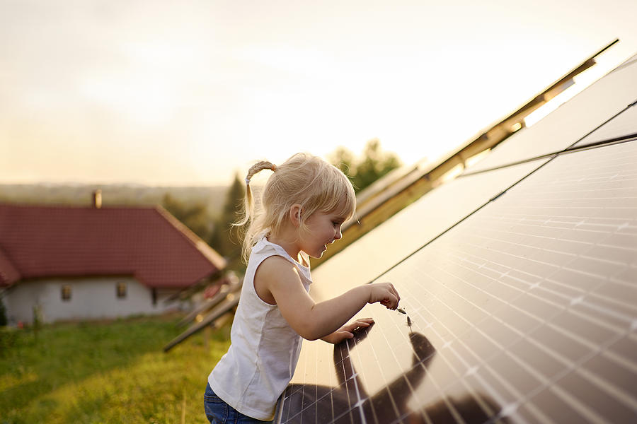 Young girl touching solar panel. Photograph by Andriy Onufriyenko