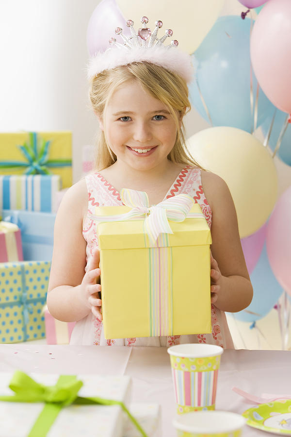 Young girl with tiara holding up birthday present Photograph by Jose Luis Pelaez