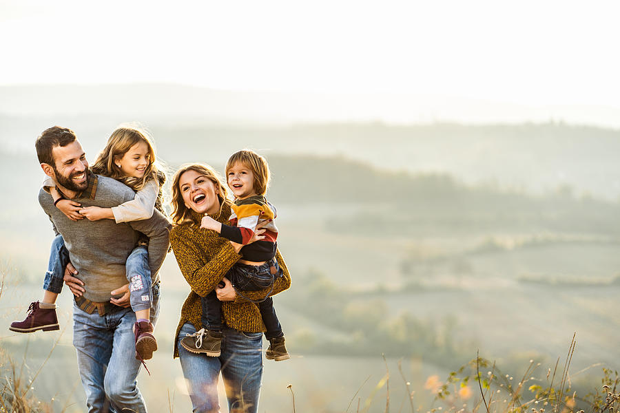 Young happy family enjoying in autumn walk on a hill. Photograph by Skynesher