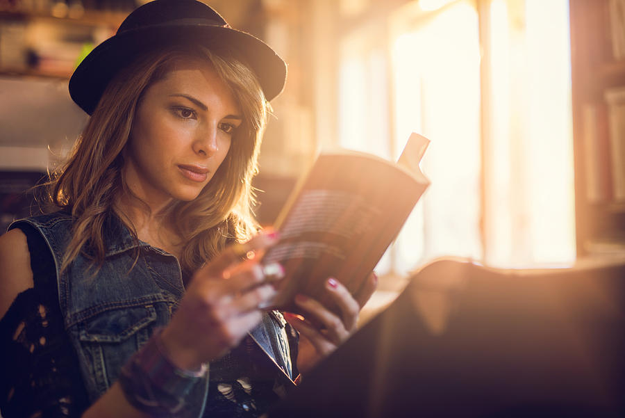 Young hipster woman relaxing while reading a book. Photograph by BraunS