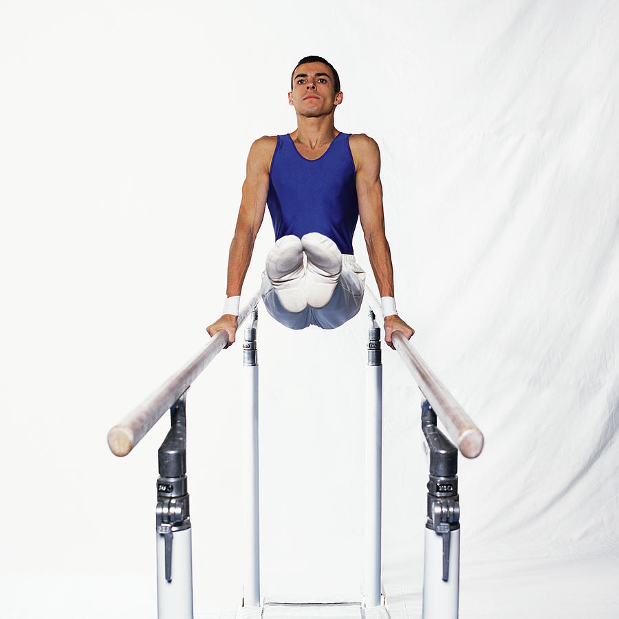 Young male gymnast on parallel bars, side view. Photograph by Dominique Douieb