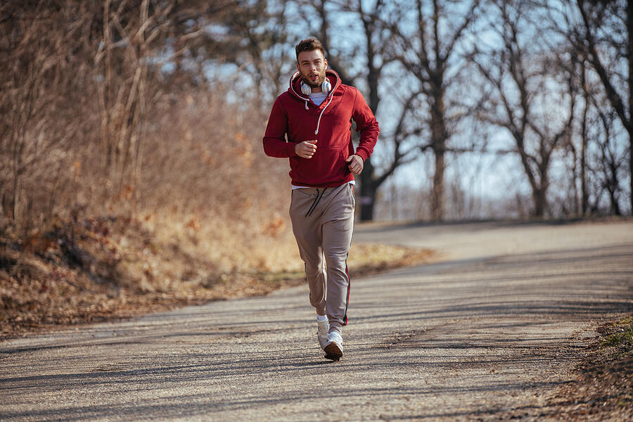 Young male runner jogging outdoors Photograph by EmirMemedovski