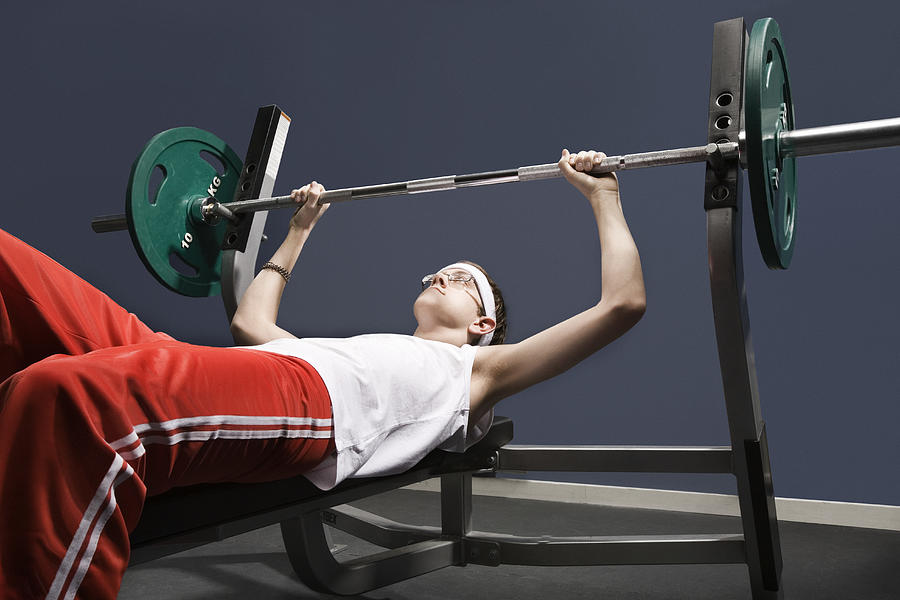 Young man about to lift weight in gym Photograph by Holloway