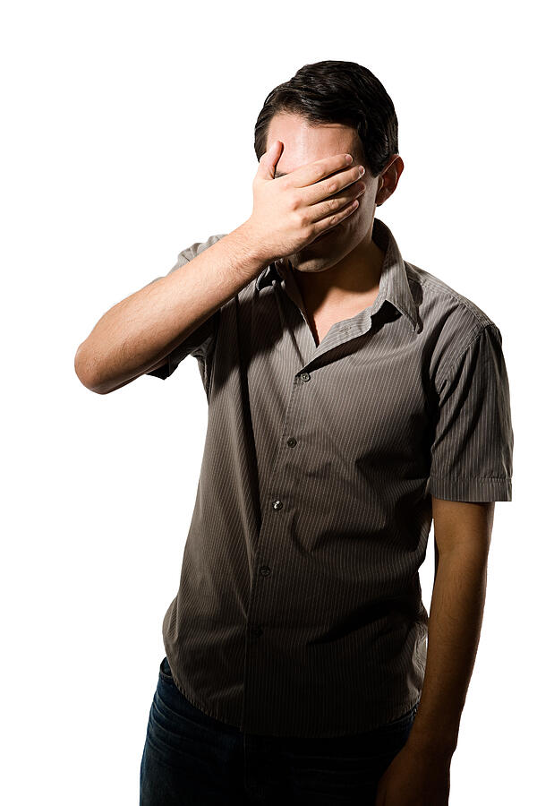 Young man covering his eyes Photograph by Image Source