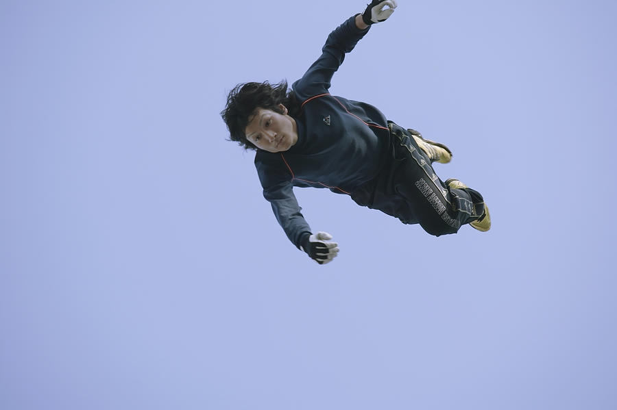 Young man flying mid-air, low angle view Photograph by Hisayoshi Osawa