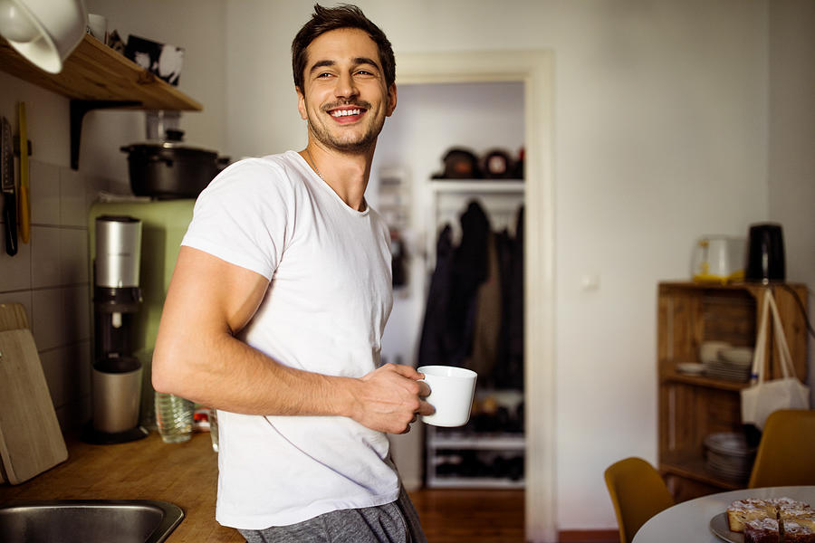 Young man in kitchen with coffee Photograph by Luis Alvarez