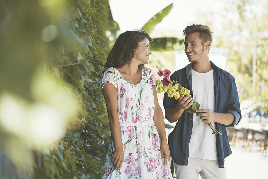 Young man in love giving flowers to his girlfriend Photograph by Fotostorm