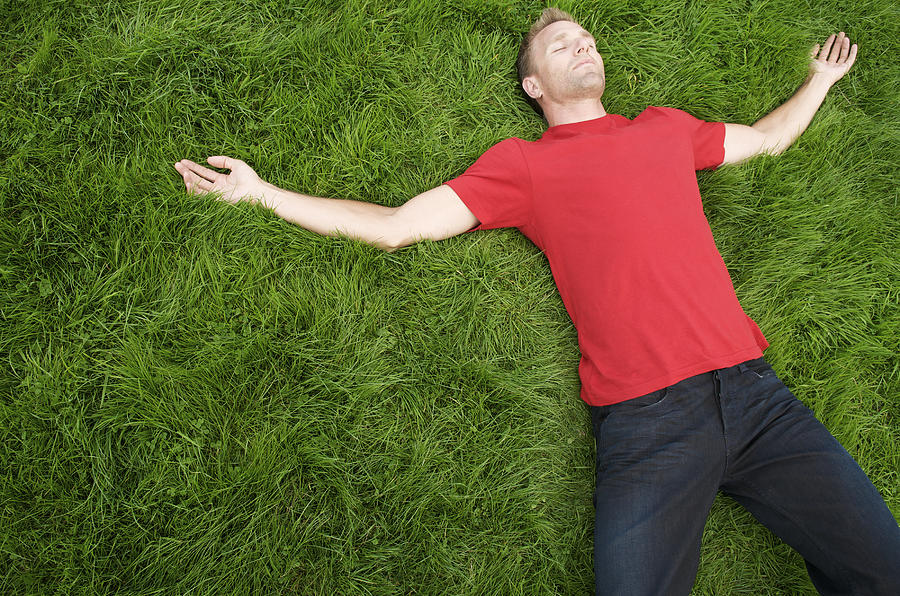 Young Man in Red T-Shirt Relaxing on Green Grass Photograph by PeskyMonkey