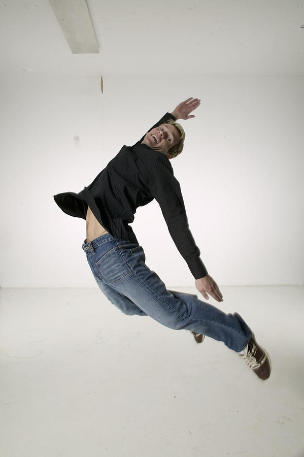 Young man jumping up for joy, portrait Photograph by Photodisc