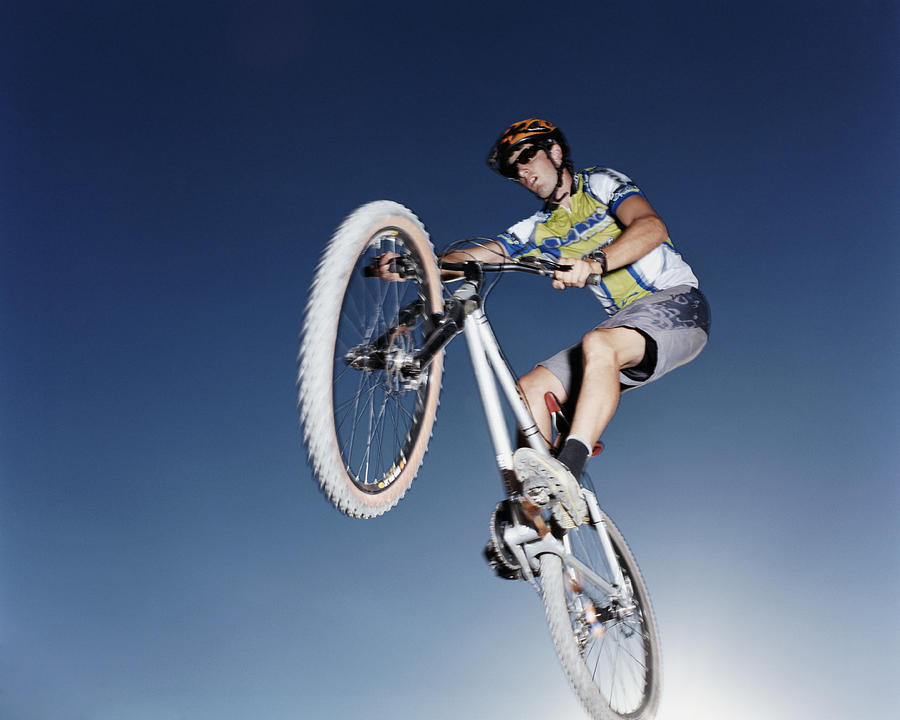 Young Man on a Mountain Bike in Mid Air Photograph by Digital Vision.