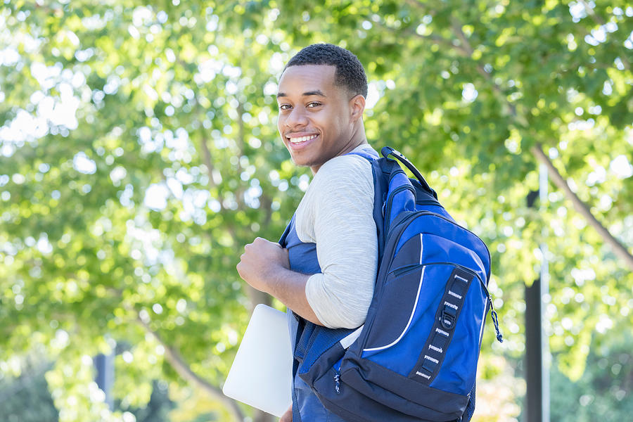 Young man smiles for camera on first day of college Photograph by SDI Productions