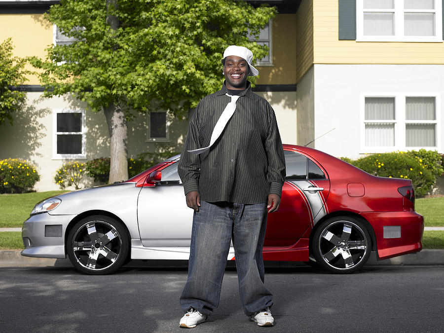 Young man standing in front of customized car, portrait Photograph by Siri Stafford
