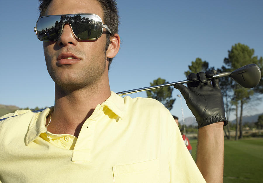 Young Man Standing on a Golf Course Wearing Sunglasses Photograph by Digital Vision.