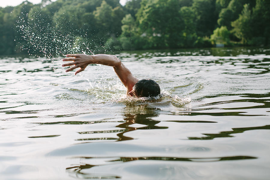 Young man swimming in a lake Photograph by Alvarez