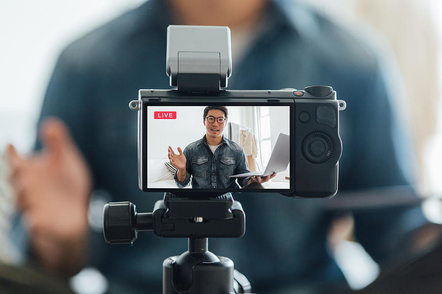 Young Man Vlogging Through Video Camera At Home Photograph by Oscar Wong