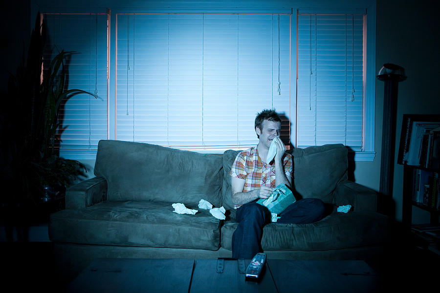 Young man watching tv, crying Photograph by Image Source
