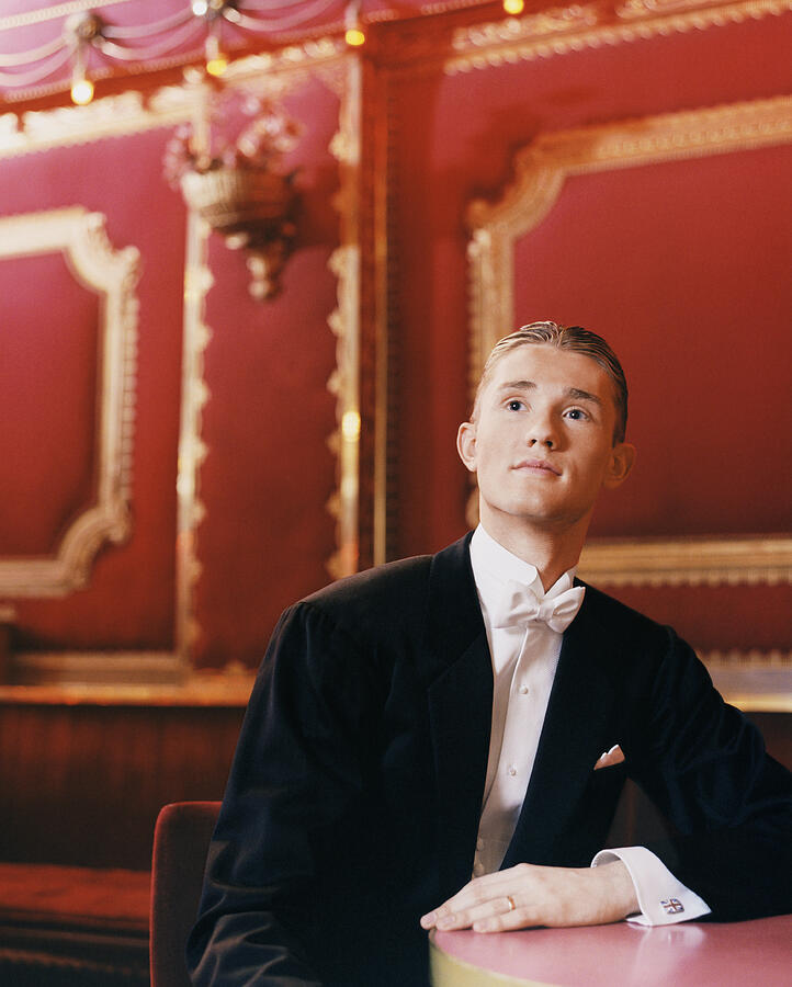 Young Man Wearing a Dinner Jacket Sitting at a Table Watching Ballroom Dancing Photograph by Digital Vision.