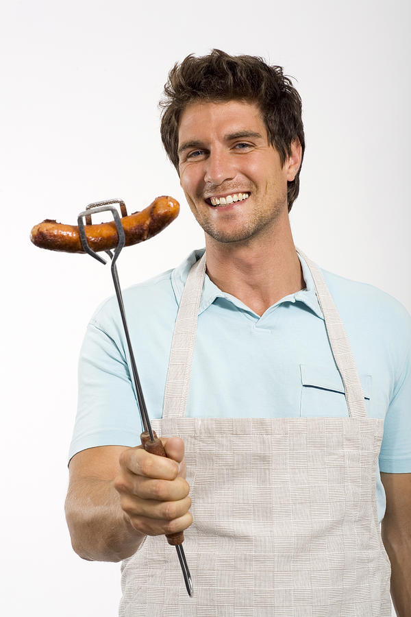 Young man with grilled sausage Photograph by Westend61