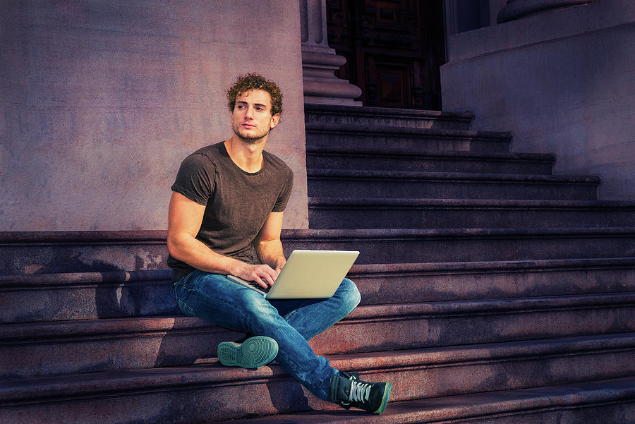 Young Man Working On Laptop Computer, Sitting On Stairs Outside Photograph
