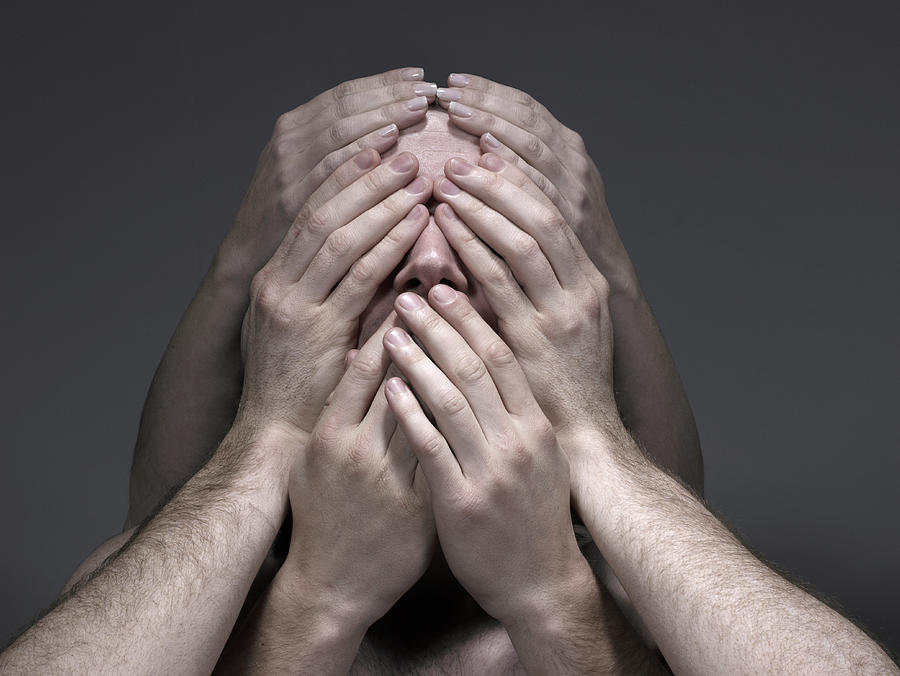 Young men and woman covering face, close-up Photograph by Flashpop
