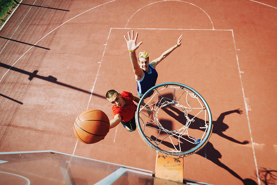 Young men playing basketball one on one Photograph by Drazen_