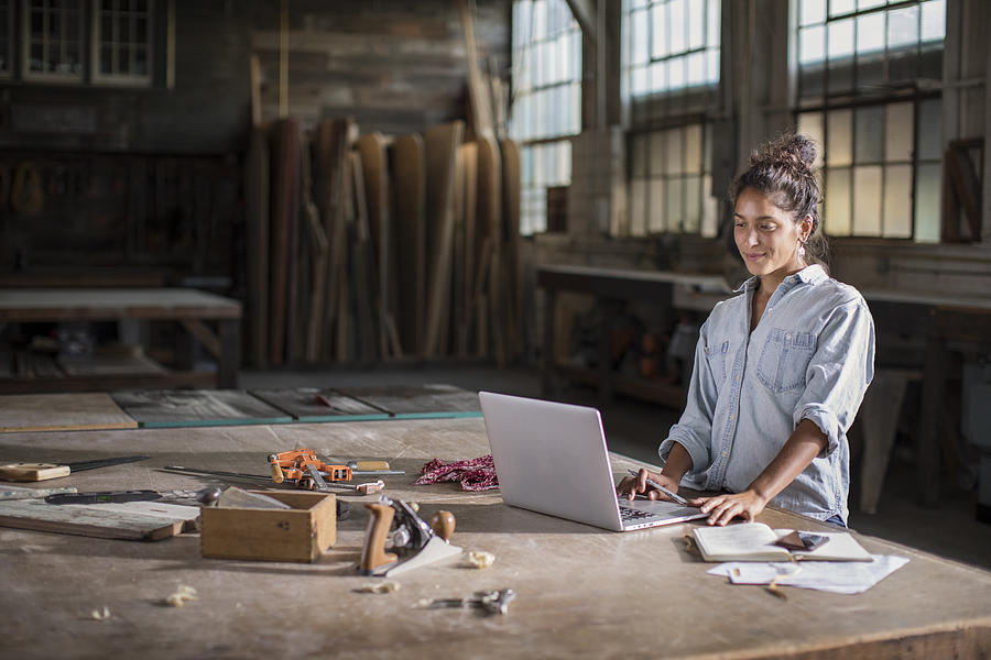 Young Mixed Race Female Entrepreneur Solving a Complicated Business Challenge with Pencil, Laptop, Carpentry Tools, and Confidence Photograph by Justin Lewis