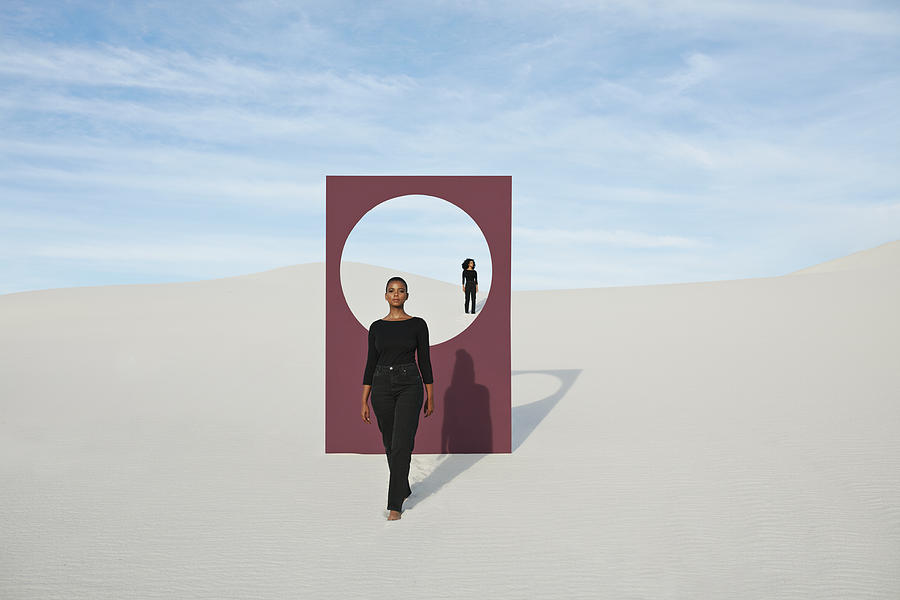 Young models with portal standing at desert against sky Photograph by Klaus Vedfelt