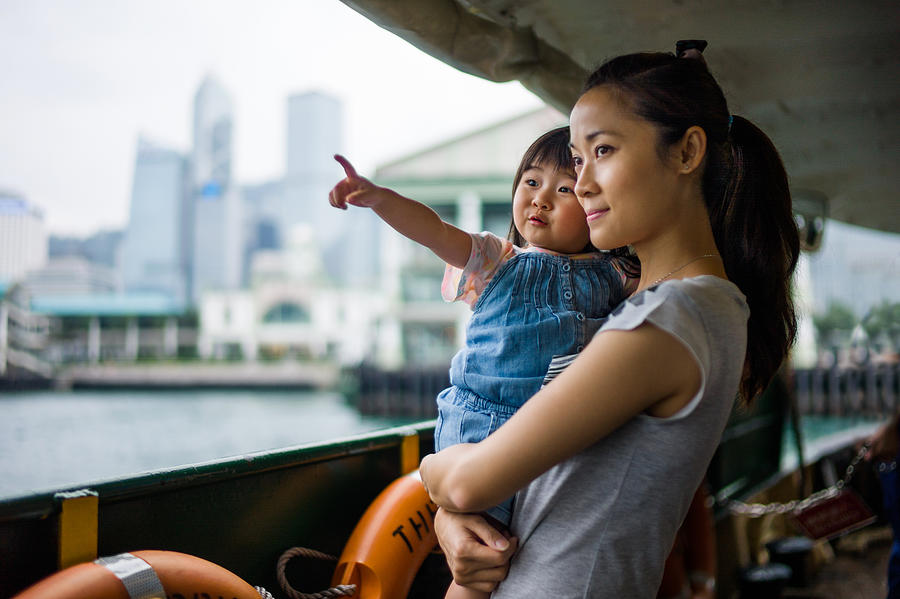 Young mom holding & talking to toddler on a ferry Photograph by images by Tang Ming Tung