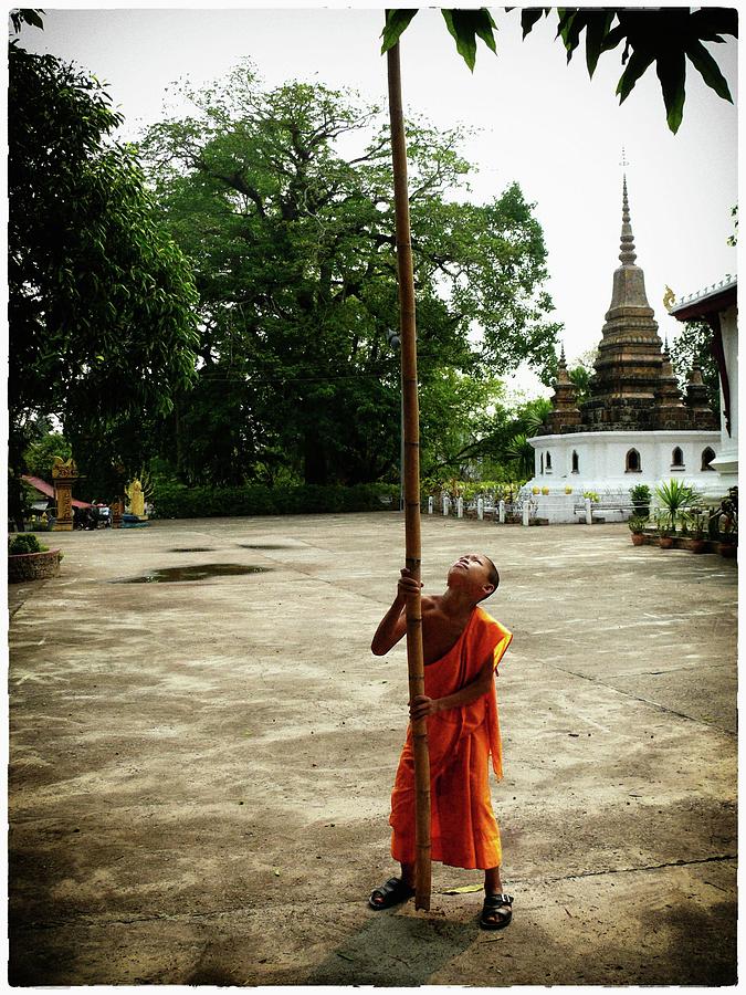 Young monk with bamboo stick Photograph by Robert Bociaga