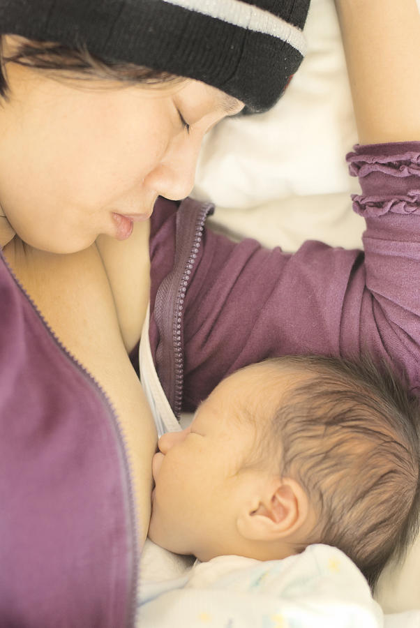 Young mother breast feeding newborn baby boy Photograph by Lawren