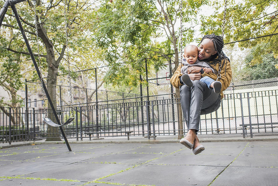 Young mother playing with infant daughter in city park Photograph by Tony Anderson