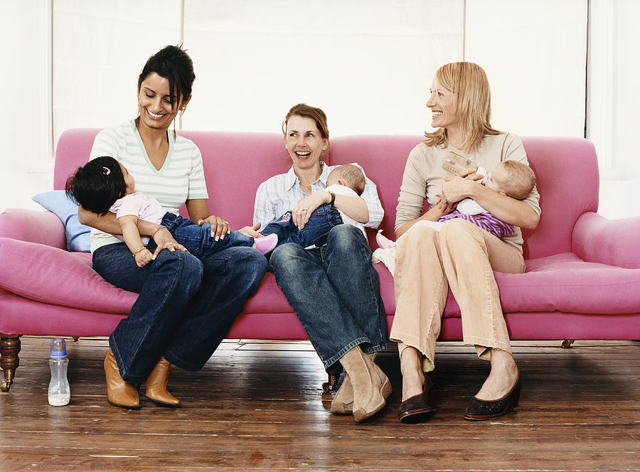 Young Mothers with Their Babies on a Pink Sofa Photograph by Digital Vision.