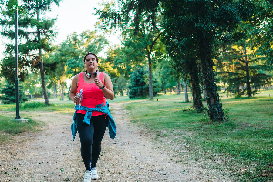 Young overweight woman running Photograph by Urbazon