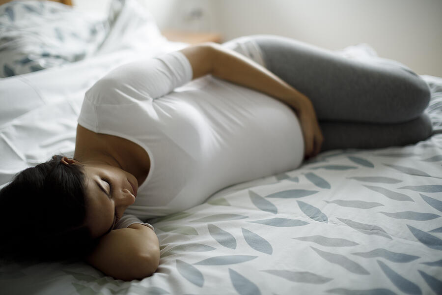 Young pregnant woman lying in bed Photograph by Damircudic