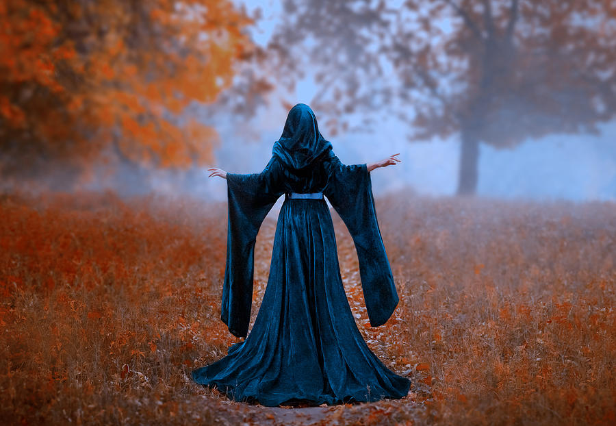 Young Priestess Holds A Secret Rite Of Sacrifice, Is Alone In The Autumn Forest On A Large Glade. The Escaped Queen Wore A Blue Velvet Cloak-dress With Wide Sleeves. Magnificent Amazing Art Photo Photograph by Kharchenko_irina7