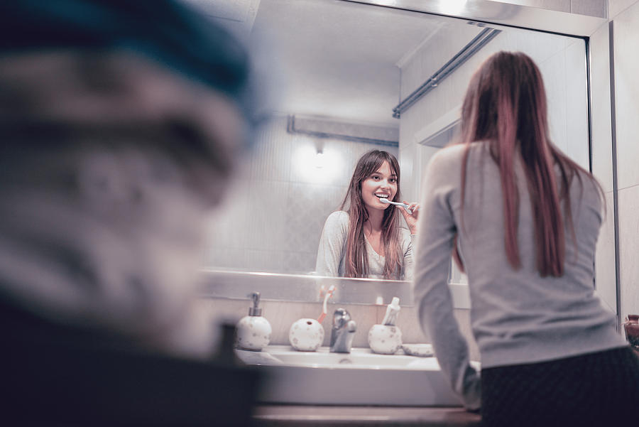 Young Smiling Female Brushing Her Teeth Before Bed Photograph by AleksandarGeorgiev