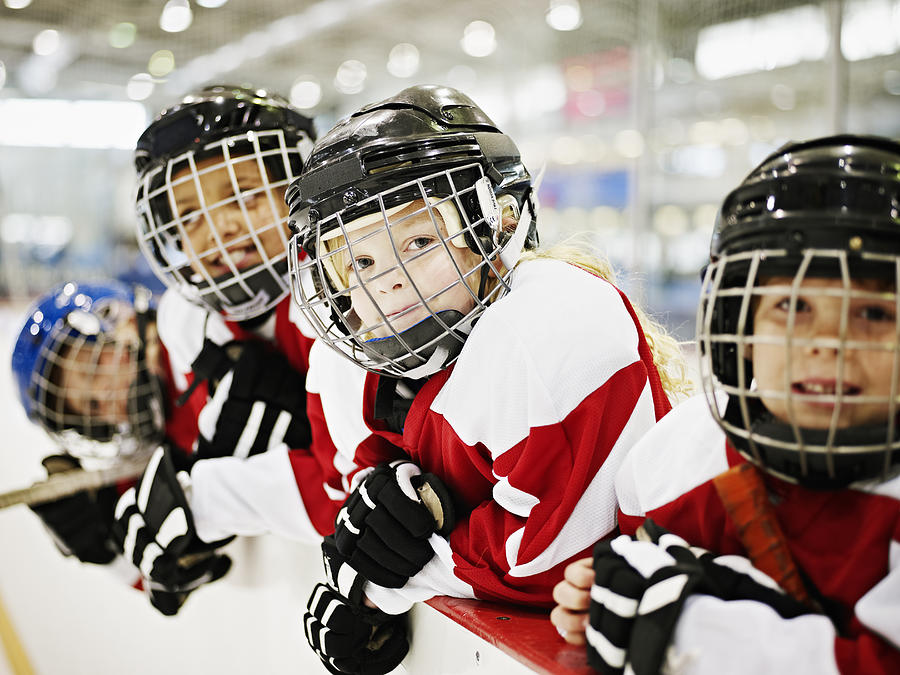 Young smiling ice hockey players in players box Photograph by Thomas Barwick