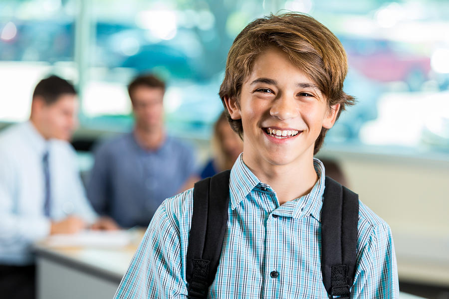Young teenage male student smiling during parent teacher conference Photograph by SDI Productions