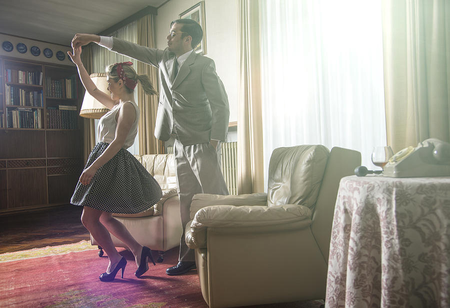Young vintage couple dancing rock n roll in sitting room Photograph by Guido Cavallini