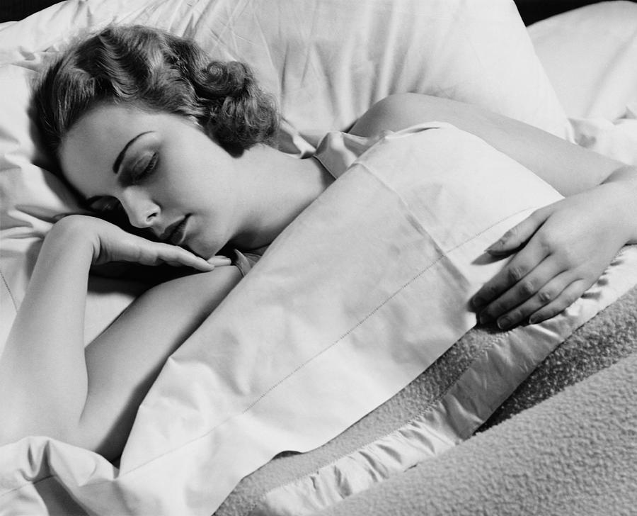 Young woman asleep in bed, (B&W), close-up Photograph by George Marks
