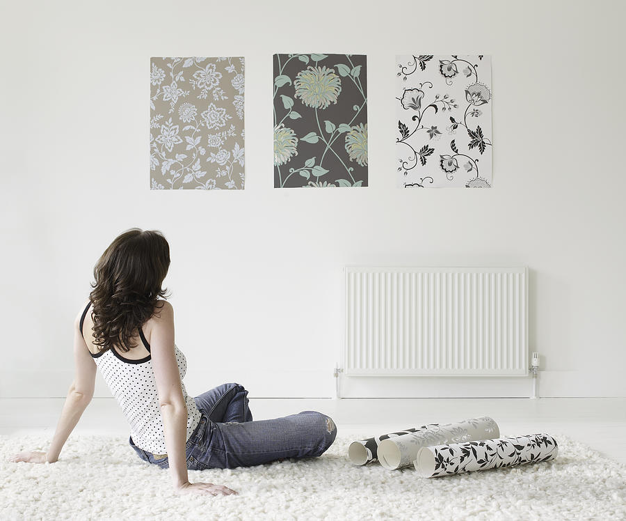 Young woman choosing wall paper for home Photograph by Mike Harrington