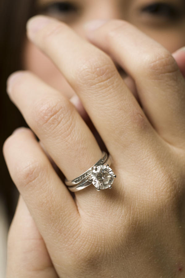 Young woman, close up of ring on finger Photograph by Photodisc