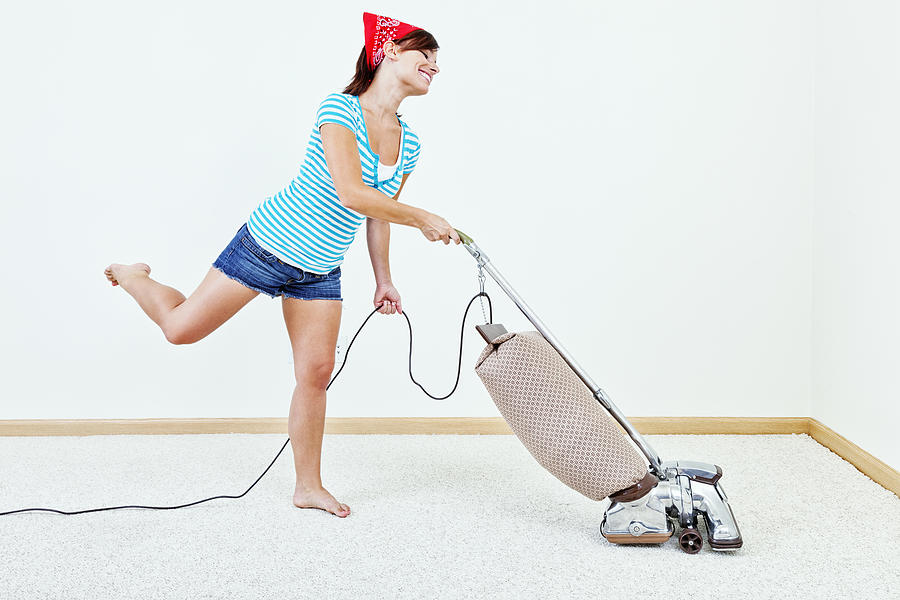 Young Woman Dancing with Vacuum Cleaner Photograph by Jhorrocks