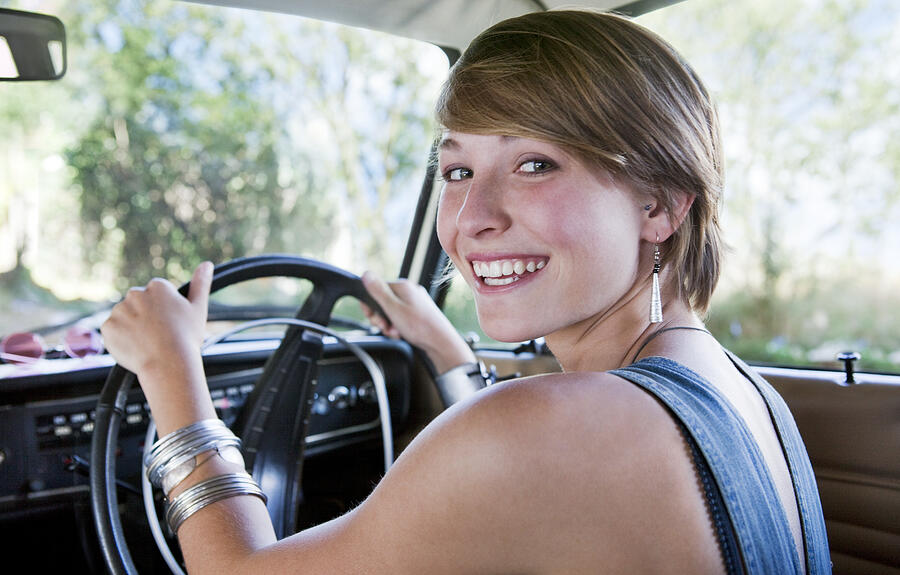 Young woman driving car, smiling Photograph by Dimitri Otis