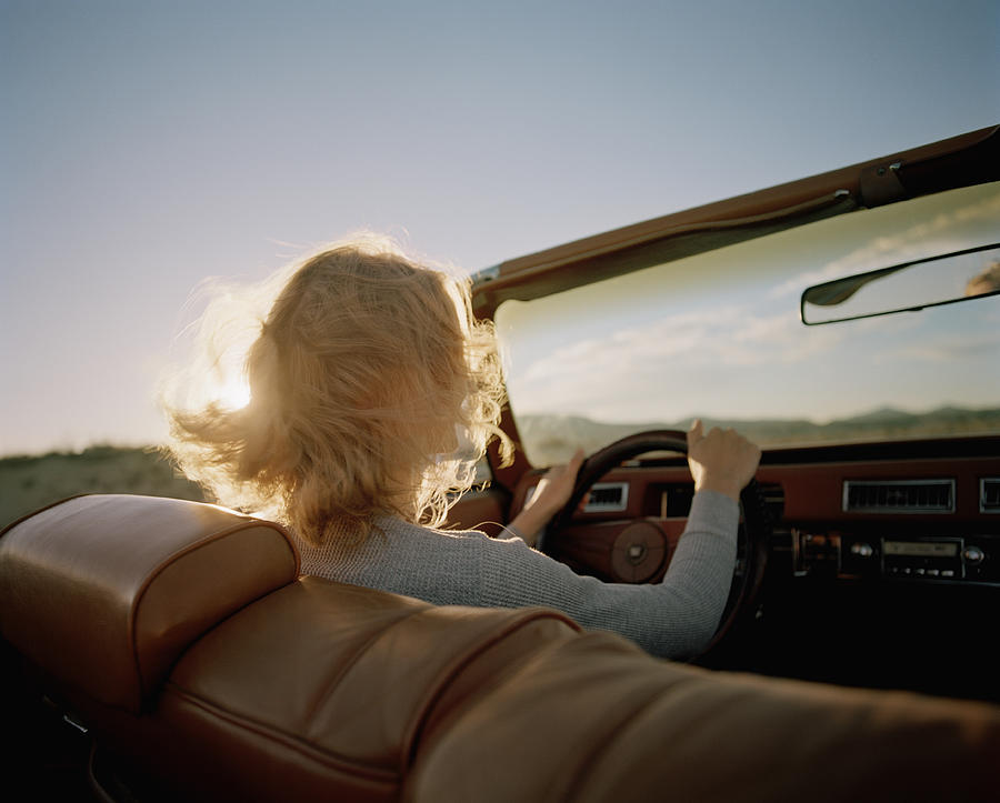 Young woman driving convertible, rear view Photograph by Matthias Clamer